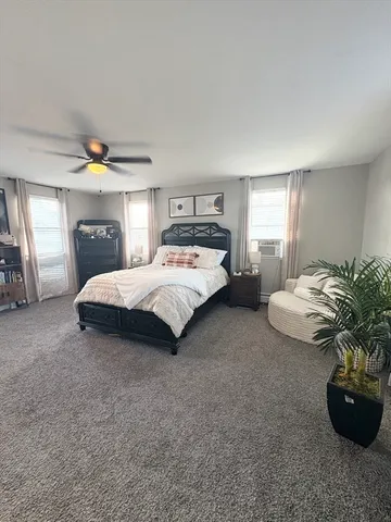 a spacious bedroom with a bed and a potted plant