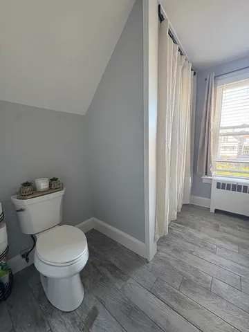 a white toilet sitting in a room next to a window
