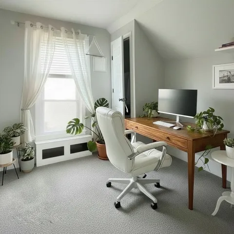 a view of a workspace with furniture and a window