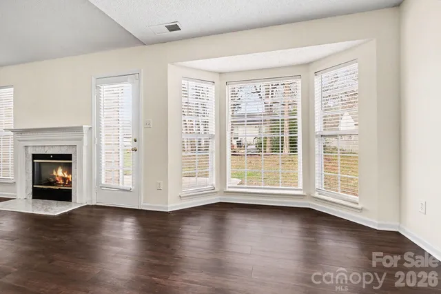 a view of a room with wooden floor and fireplace