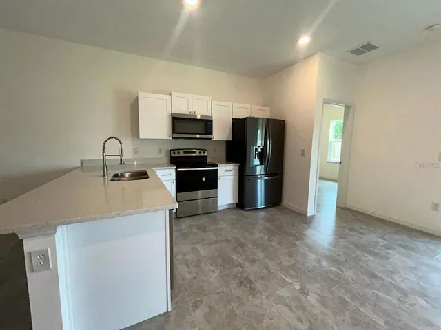 a kitchen with stainless steel appliances a sink stove and refrigerator