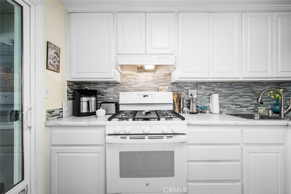 701 South Hayward Street, Unit B Anaheim, CA 92804 - Photo 11 of 31 Glass door to the left accesses the laundry area. Modern glass tile backsplash.
