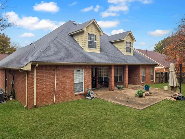 a pathway of a house with a small yard and wooden fence