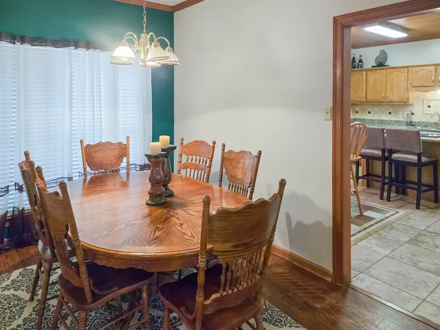 a kitchen with stainless steel appliances granite countertop a table chairs sink and cabinets