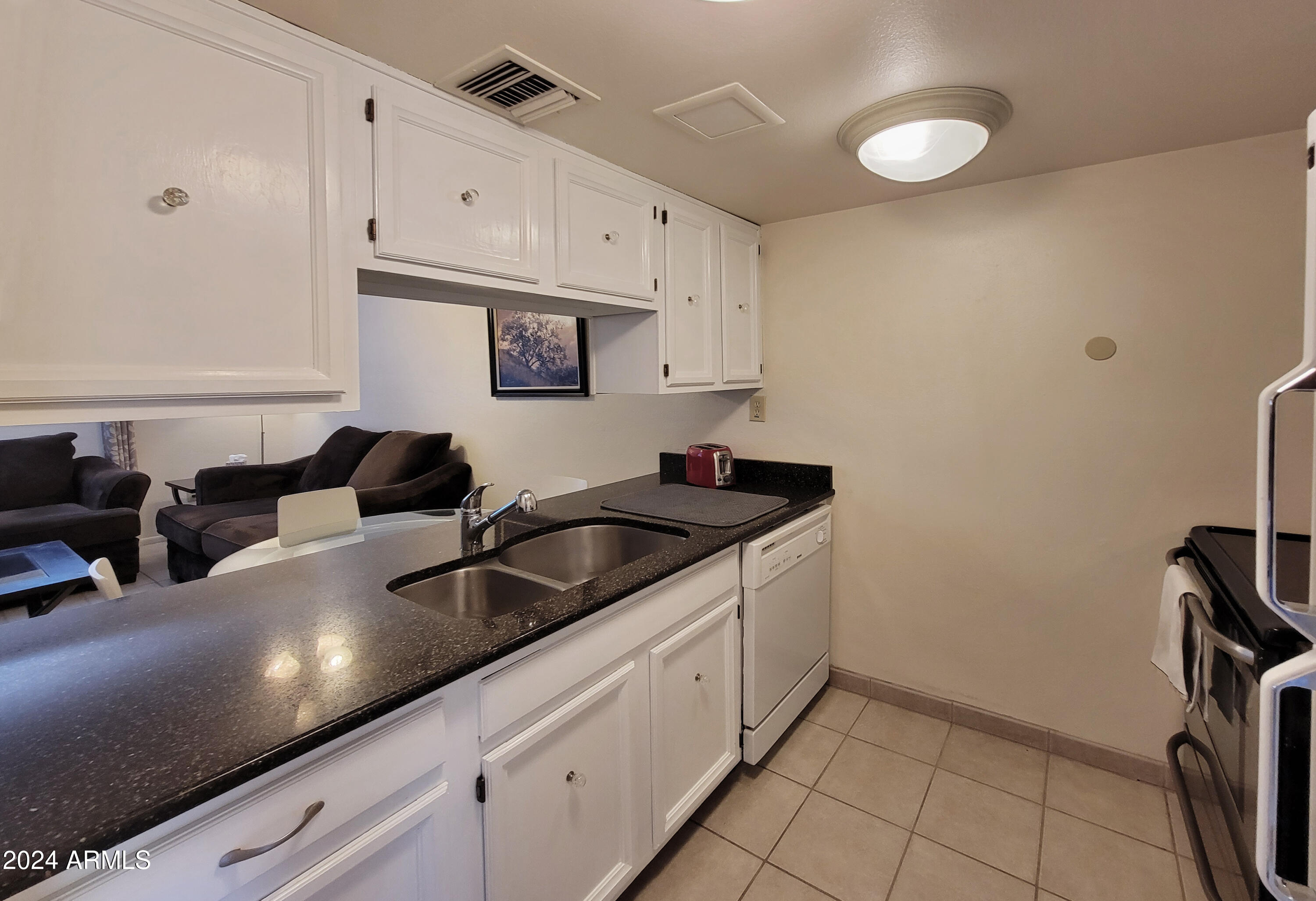 7436 East Chaparral Road, Unit 120B Scottsdale, AZ 85250 - Photo 5 of 24 a kitchen with stainless steel appliances granite countertop a sink stove and cabinets
