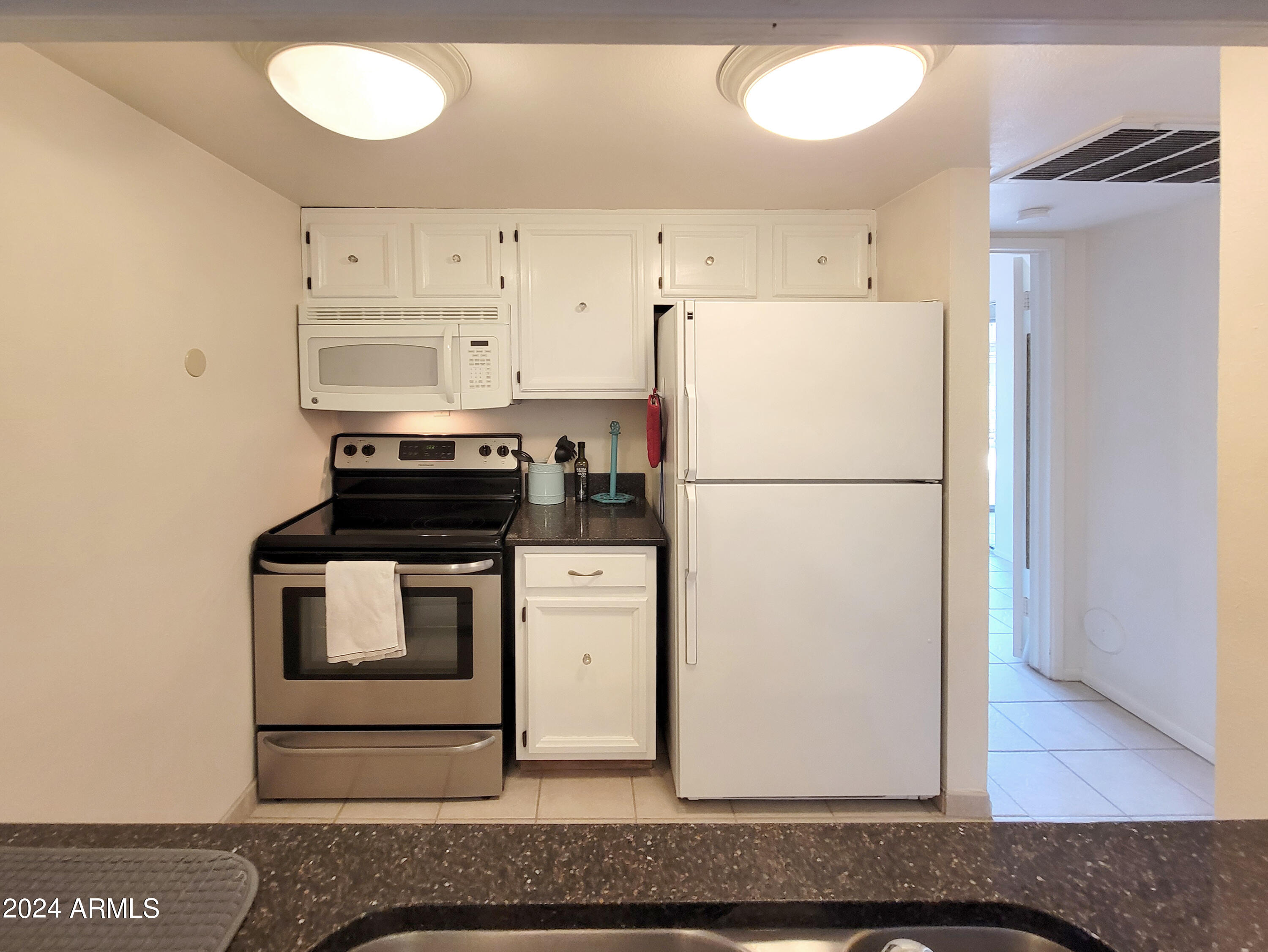 7436 East Chaparral Road, Unit 120B Scottsdale, AZ 85250 - Photo 7 of 24 a kitchen with a refrigerator and a stove