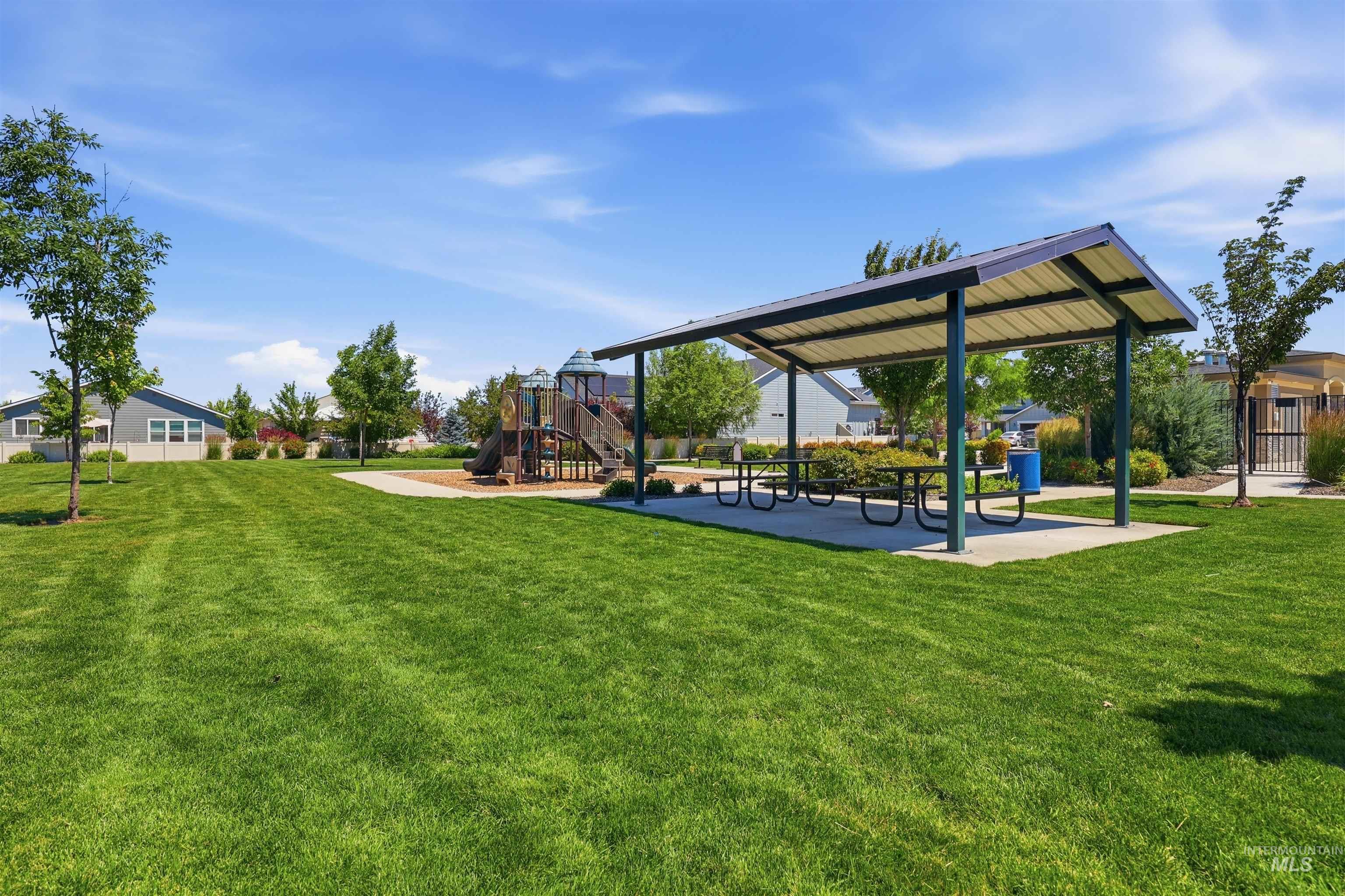 3811 West Maypearl Street Meridian, ID 83642 - Photo 38 of 39 Expansive green space featuring a covered pavilion, multiple picnic tables, and a dedicated play structure