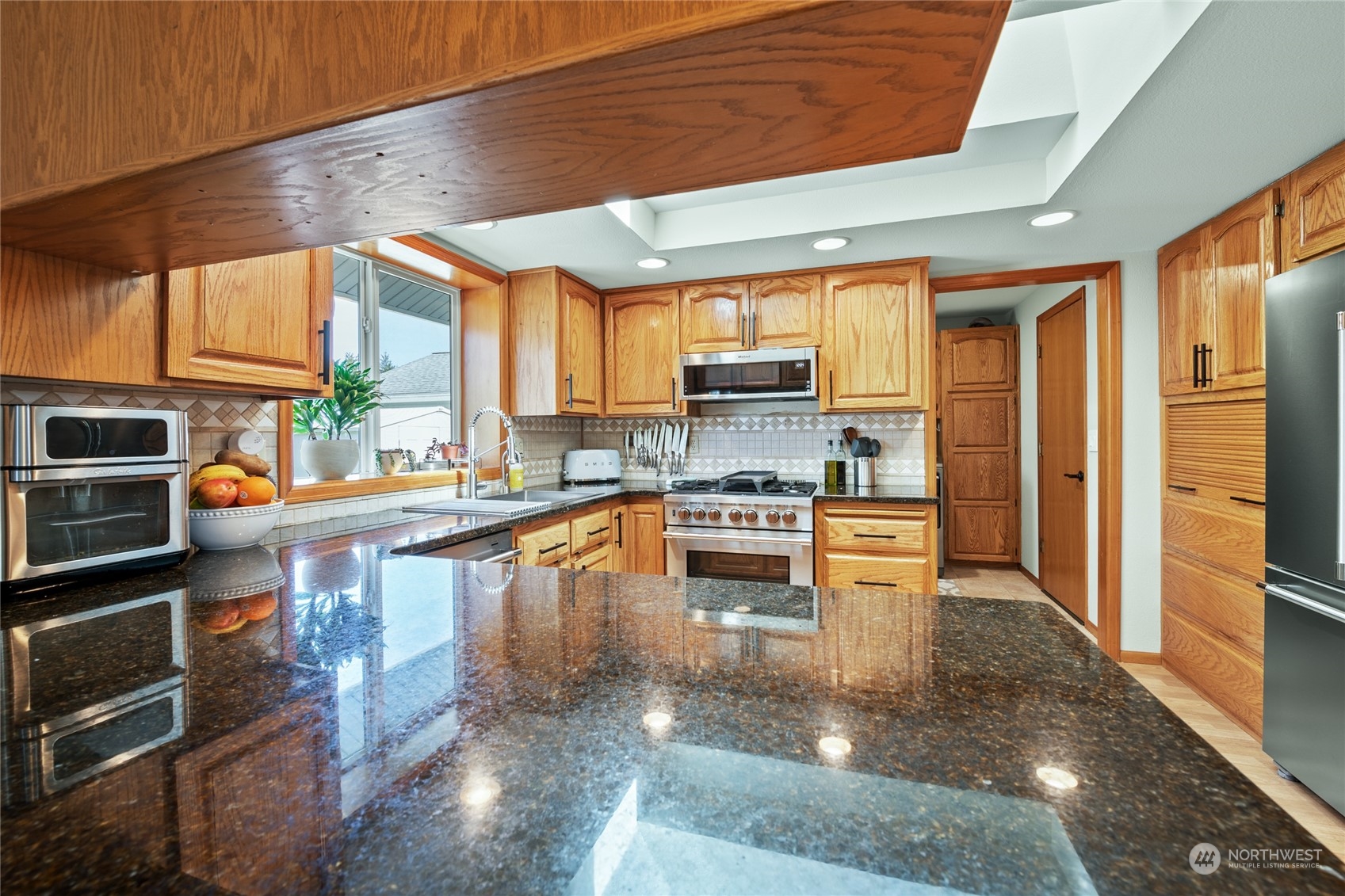 323 Edgewater Lane Lynden, WA 98264 - Photo 6 of 40 a kitchen with stainless steel appliances granite countertop a stove a sink and a microwave