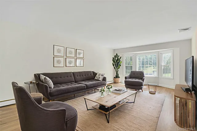 a living room with furniture a flat screen tv and a window