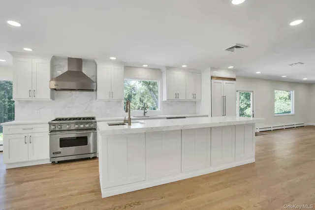 a kitchen with stainless steel appliances granite countertop a stove a sink and a refrigerator