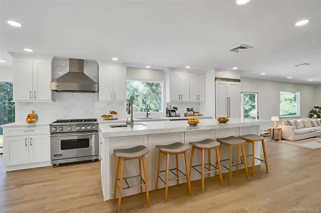 a kitchen with stainless steel appliances a table and chairs in it