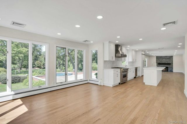 a view of kitchen with stainless steel appliances kitchen island wooden floor and window