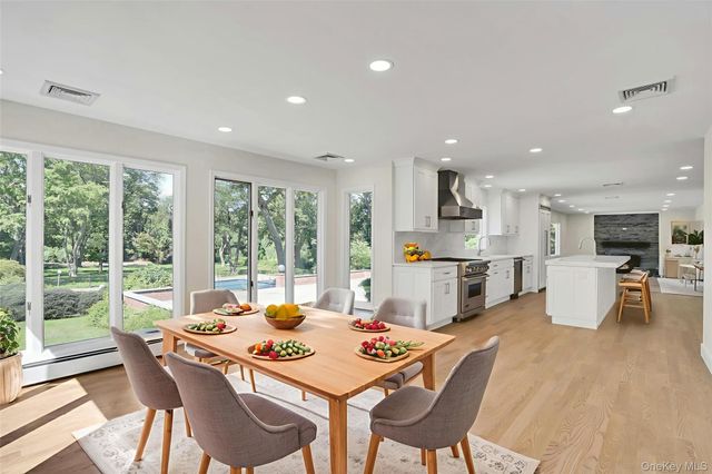 a dining room with furniture a large window and a view of kitchen