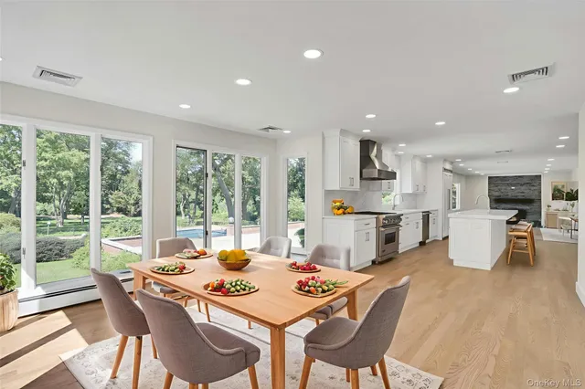 a dining room with furniture a large window and a view of kitchen