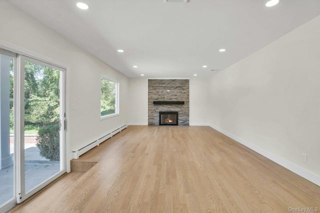 en empty room with a fireplace and windows