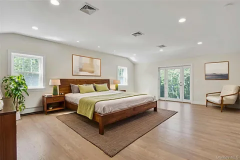 a spacious bedroom with a large bed and a wooden floor