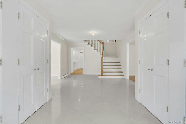 a view of a hallway with stairs and a window