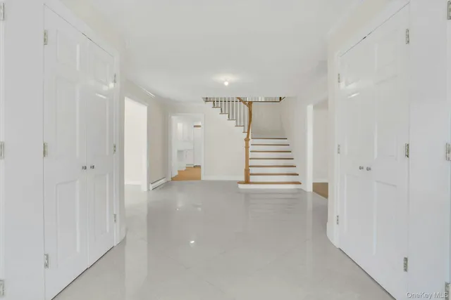 a view of a hallway with stairs and a window