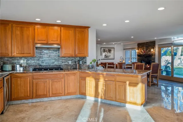 a large kitchen that has a lot of cabinets table and chairs