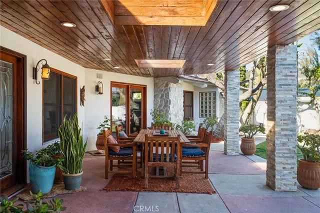 a view of a patio with a table and chairs potted plants