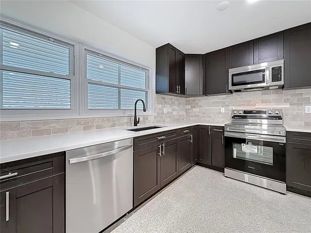 a kitchen with stainless steel appliances granite countertop a refrigerator and a sink