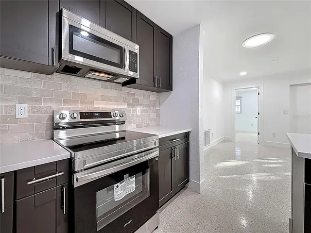 a kitchen with granite countertop cabinets stainless steel appliances and a sink