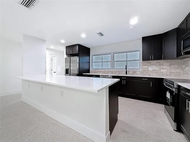 a view of a kitchen with a sink and a refrigerator