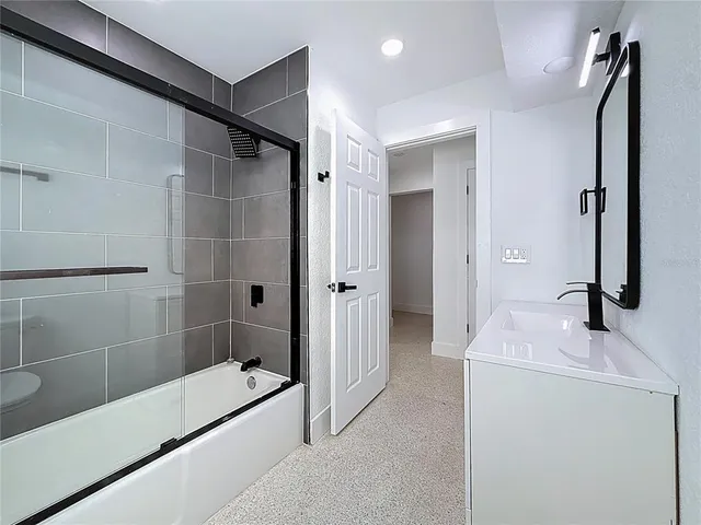 a bathroom with a shower sink and mirror