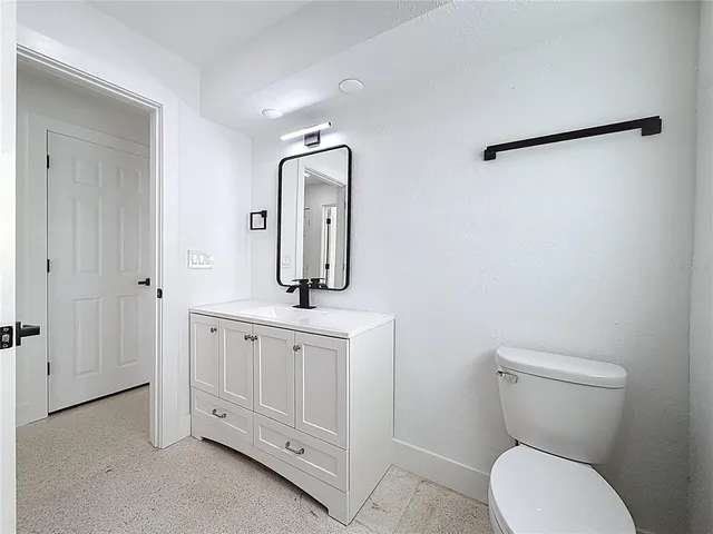 a bathroom with a granite countertop toilet and a shower