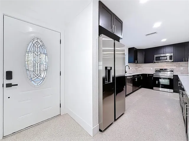 a kitchen with stainless steel appliances granite countertop a stove a sink and a refrigerator