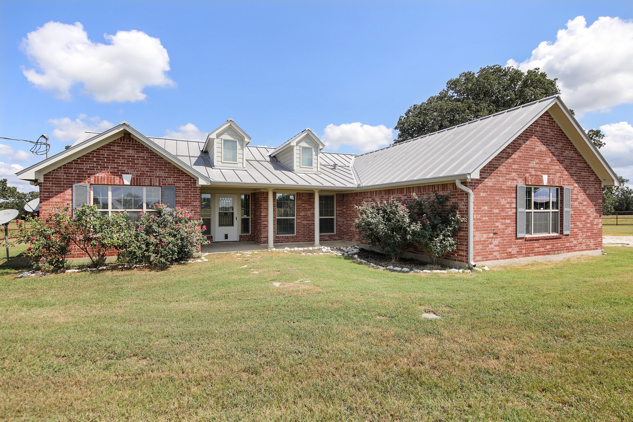 a front view of a house with a garden and yard