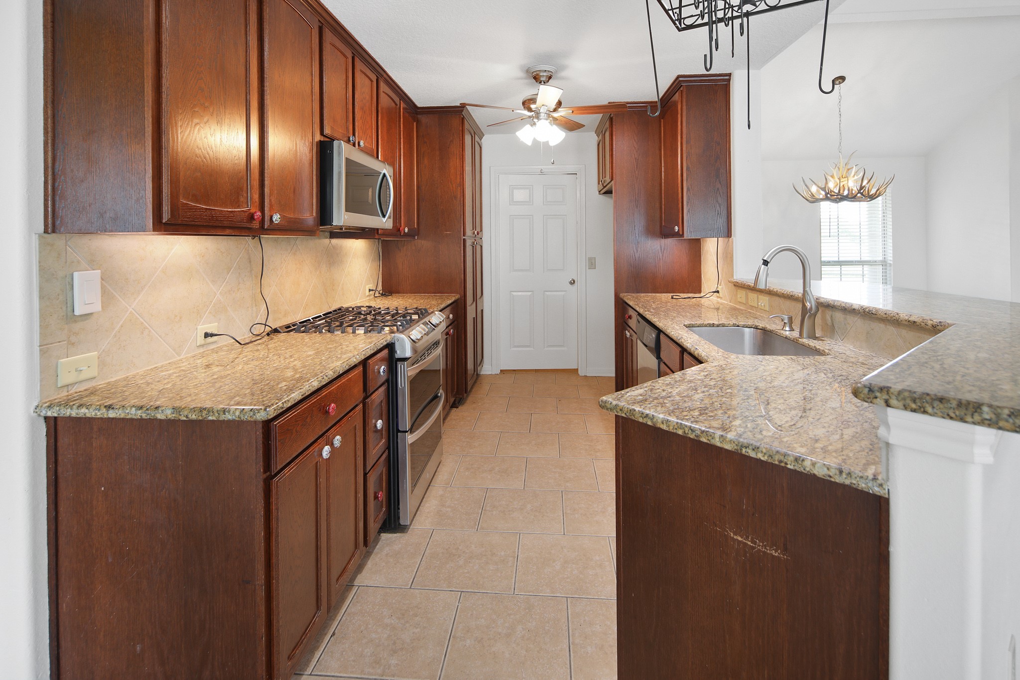 7808 Oxford Cemetery Road Madisonville, TX 77864 - Photo 10 of 16 a kitchen with stainless steel appliances granite countertop a sink a stove and a refrigerator