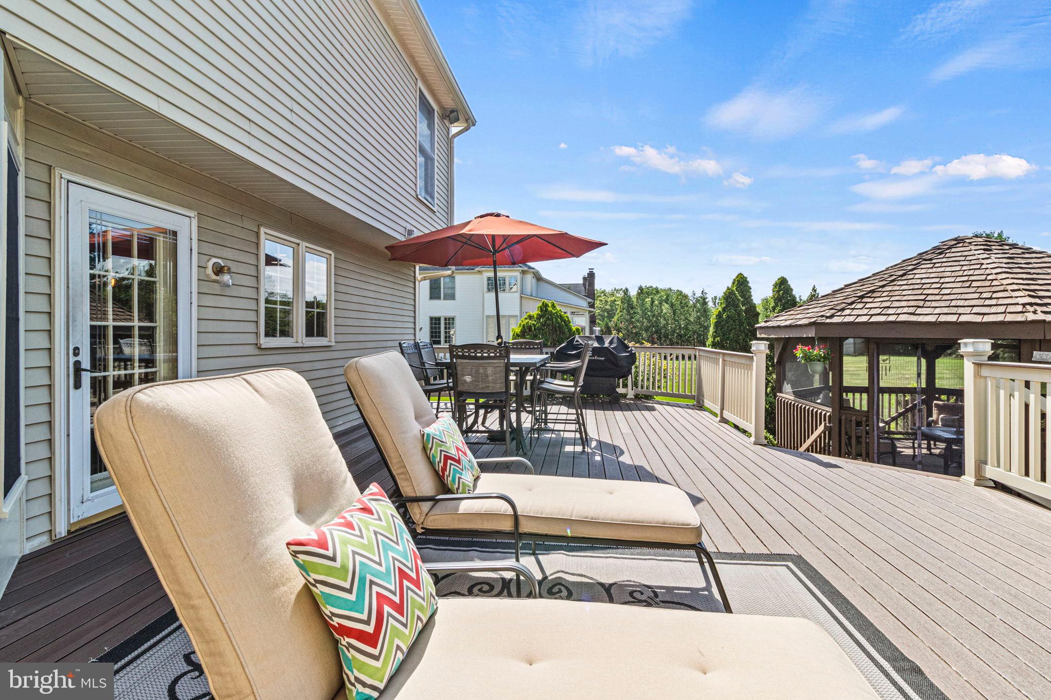 15 Byron Drive Mount Laurel, NJ 08054 - Photo 50 of 60 a view of a patio with couches table and chairs under an umbrella