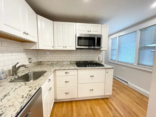 a kitchen with granite countertop a sink and a stove top oven
