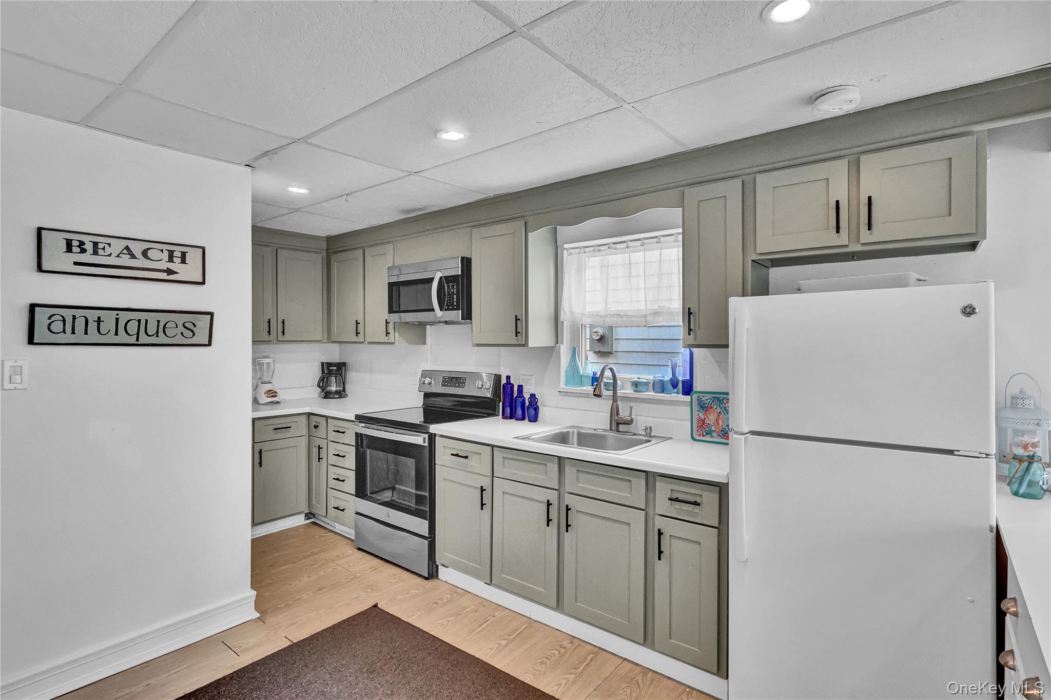 21 Cottage Road Baiting Hollow, NY 11933 - Photo 5 of 28 a kitchen with cabinets stainless steel appliances a sink and a window