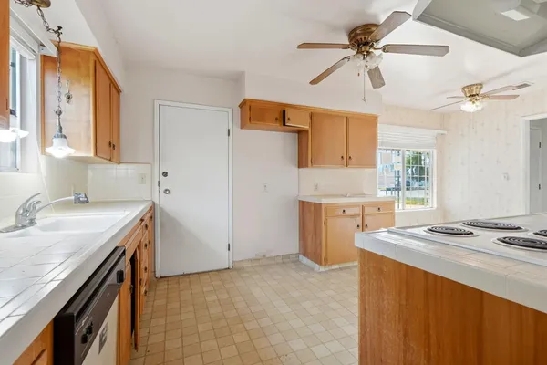 a kitchen with a stove a sink a refrigerator and a window