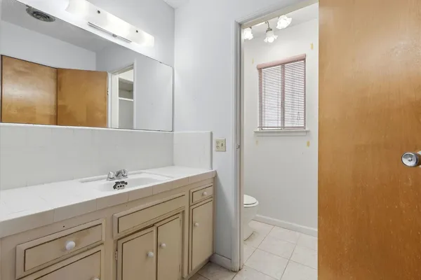 a bathroom with a sink a toilet and a mirror