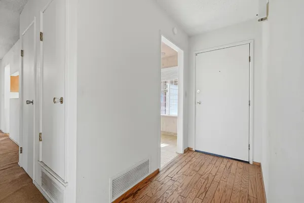 a view of a room with wooden floor and a hallway