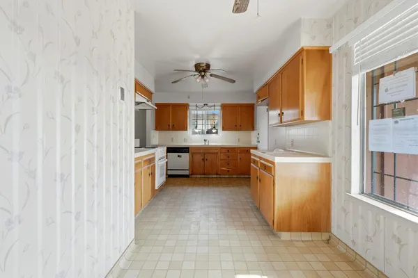 a large kitchen with stainless steel appliances a sink and cabinets