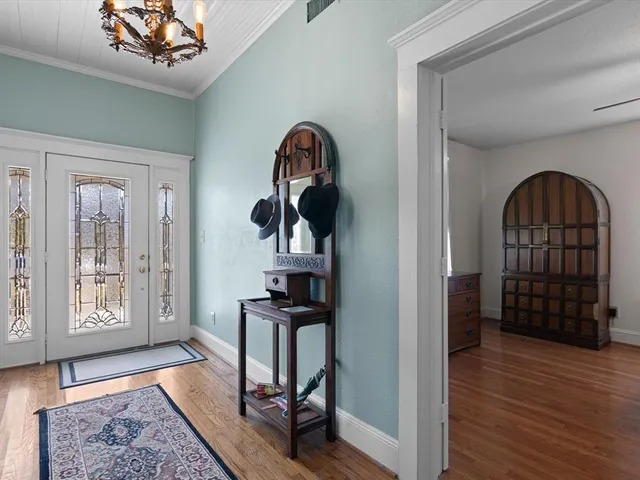 a view of a hallway with wooden floor and furniture