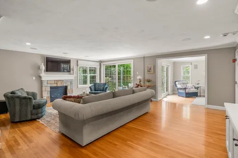 a living room with furniture floor to ceiling window and a fireplace