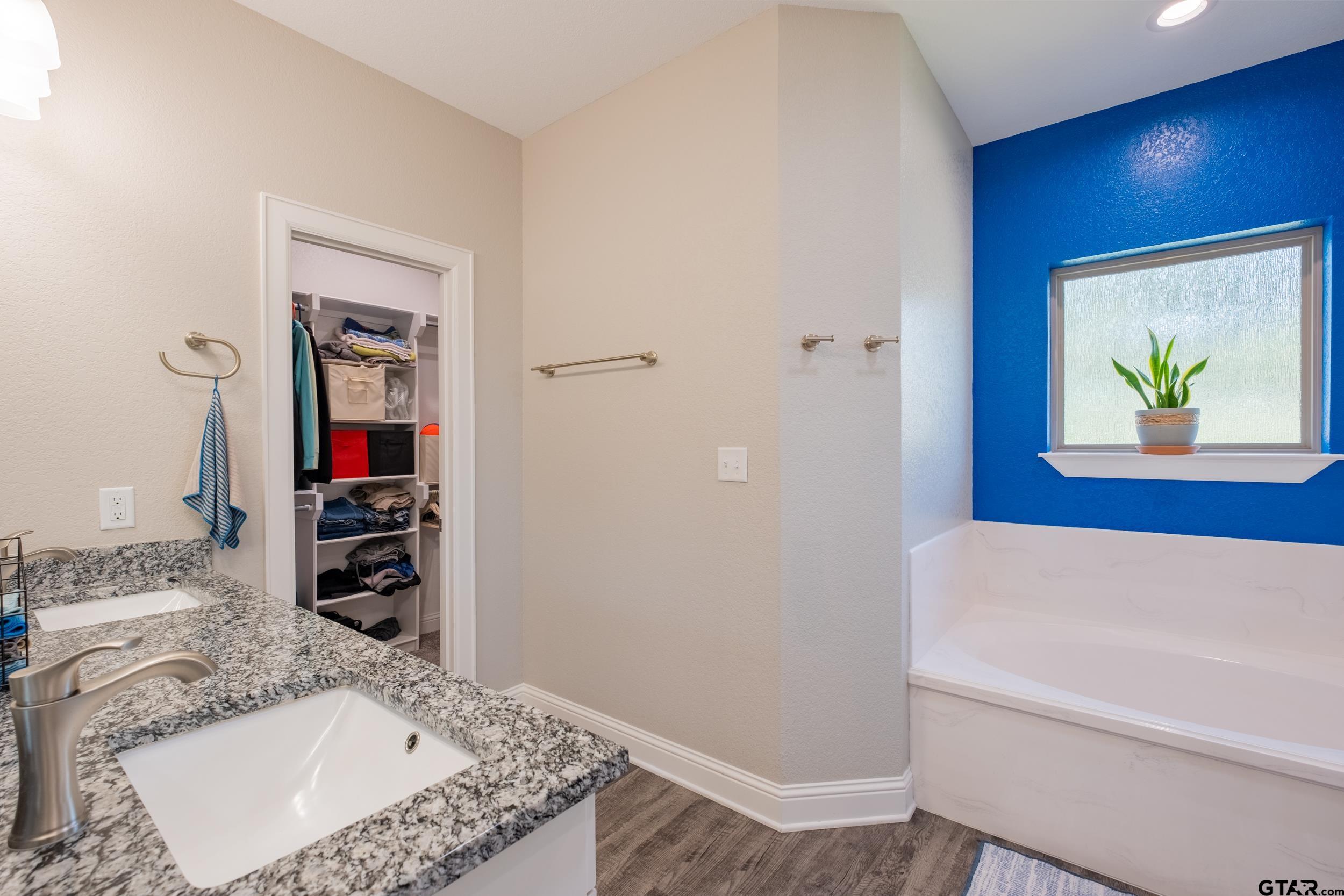 14348 County Road 452 Lindale, TX 75771 - Photo 17 of 45 a bathroom with a granite countertop sink a mirror and a bathtub