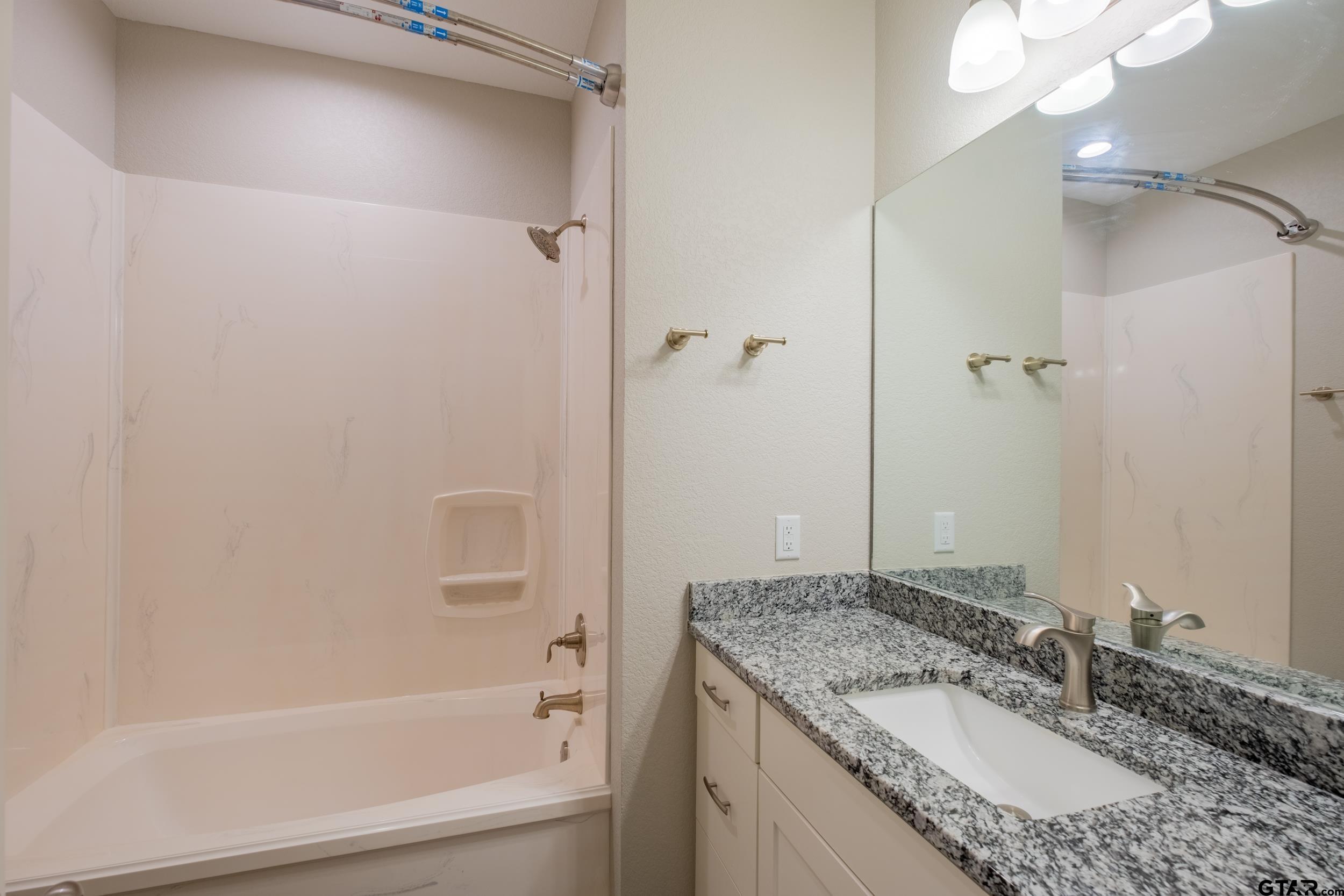 14348 County Road 452 Lindale, TX 75771 - Photo 23 of 45 a bathroom with a granite countertop sink and a mirror