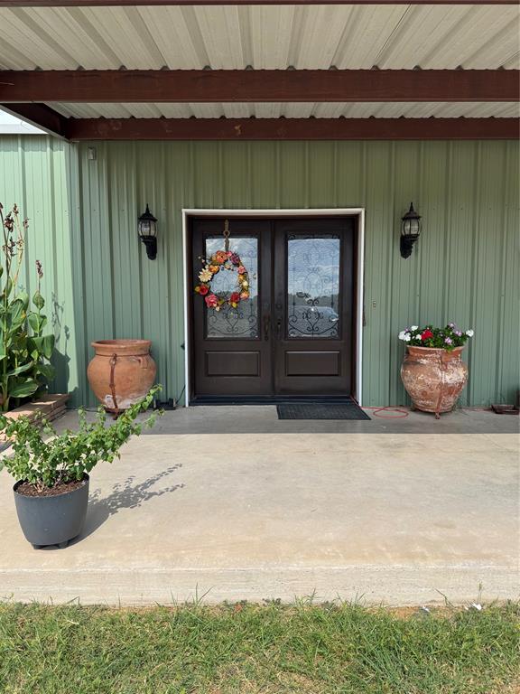 1794 Cr 527 Road Baird, TX 79504 - Photo 1 of 38 Double entry doors with decorative glass inserts, flanking wall sconces, and a covered concrete porch