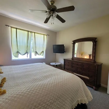 a bedroom with a bed and a flat tv screen on dresser