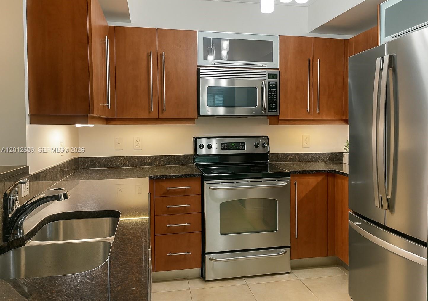 7355 Southwest 89th Street, Unit 501N Miami, FL 33156 - Photo 2 of 21 a kitchen with stainless steel appliances granite countertop a refrigerator stove and sink