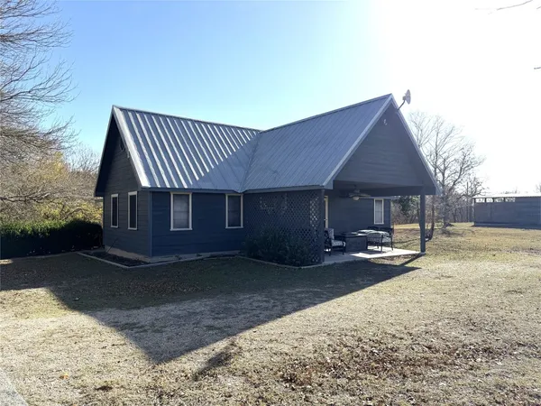 a front view of a house with a yard and seating space