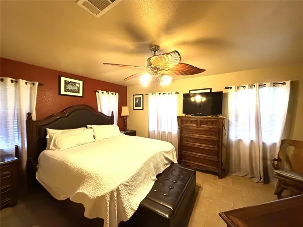 a bedroom with a bed and dresser with mirror