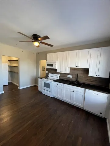 a kitchen with granite countertop a stove cabinets and wooden floor
