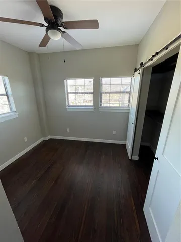 a view of a room with wooden floor and windows